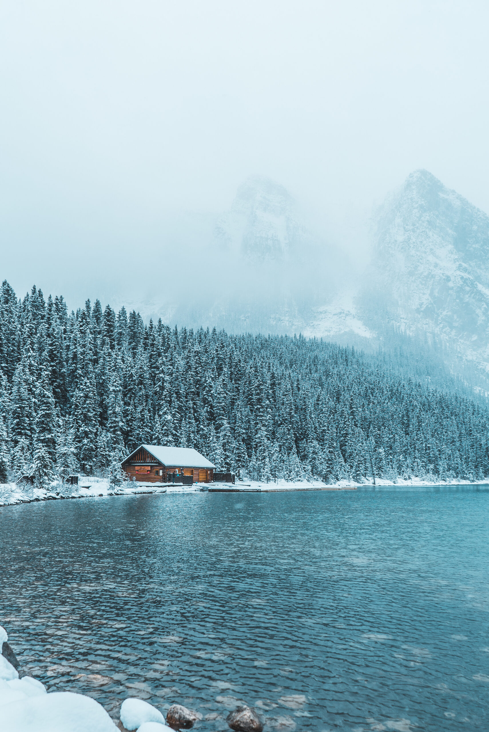 Alaska cruise winter landscape with a snowy wooden cabin by the water