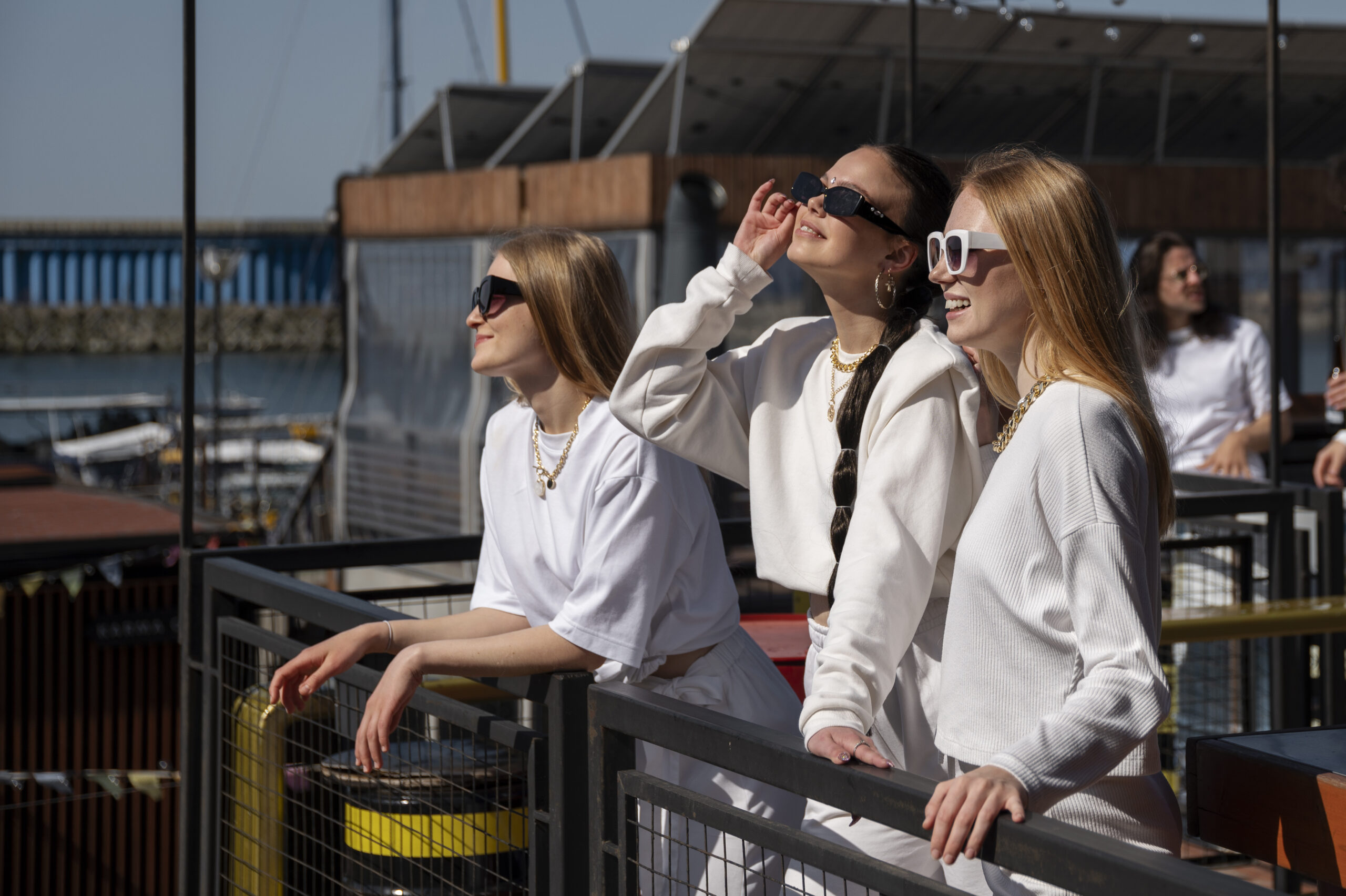 A group of young friends enjoying a cruise experience together, dressed in stylish white attire, symbolizing the fun and social aspect of cruise travel.